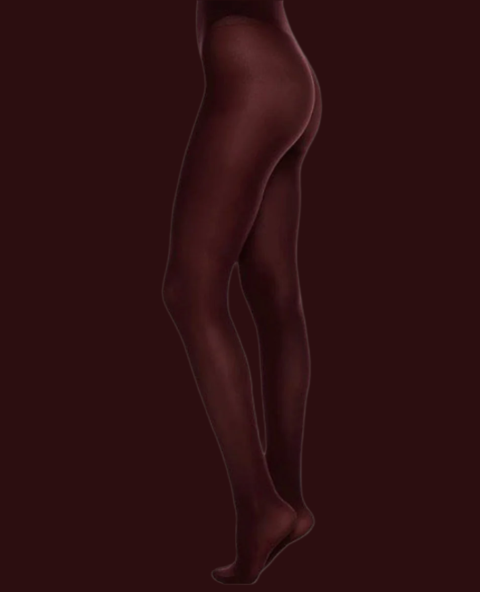 Opaque, burgundy-colored tights with a smooth, form-fitting texture, extending from the waist to the toes, made of a stretchy, nylon-blend material.