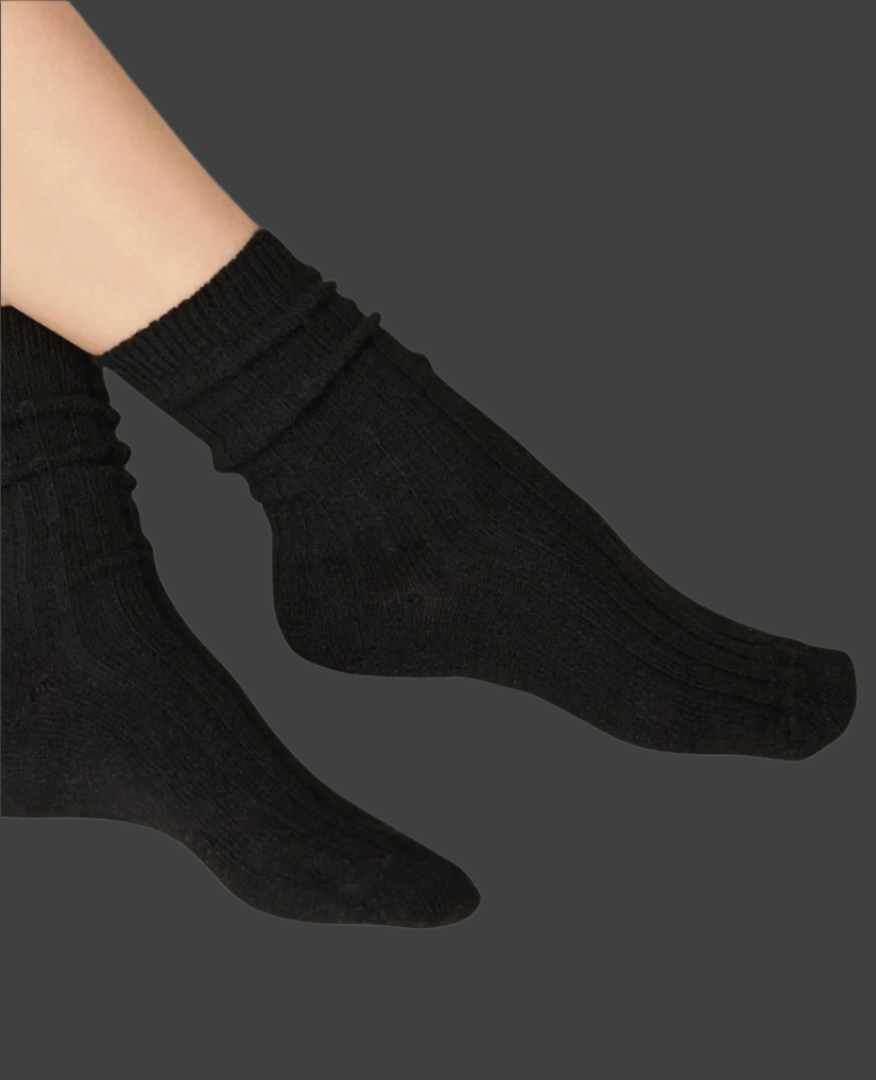 A pair of black, ribbed socks with a snug fit, featuring a soft, stretchy texture and a mid-calf length.