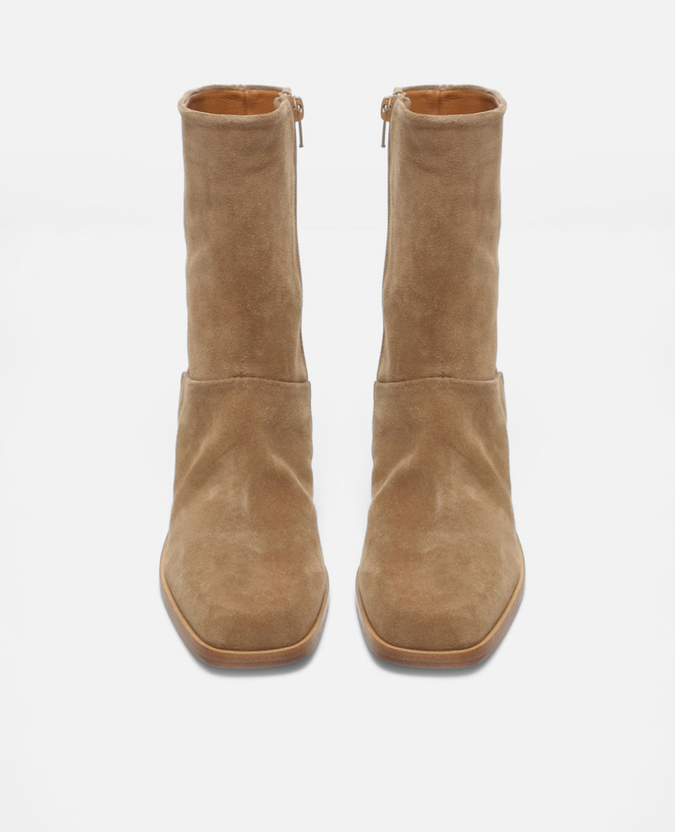 Pair of tan suede ankle boots on a white background