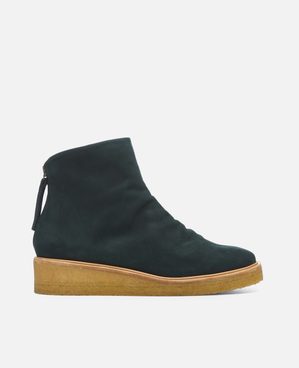 Black ankle boot with brown sole on a light gray background