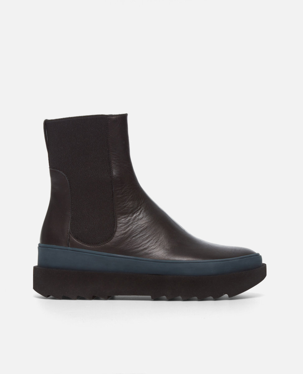 Black ankle boot with blue sole on a white background