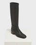 A tall, black leather boot with a smooth texture, a rounded square toe, a to-the-knee-calf height, and a low, chunky heel. 2