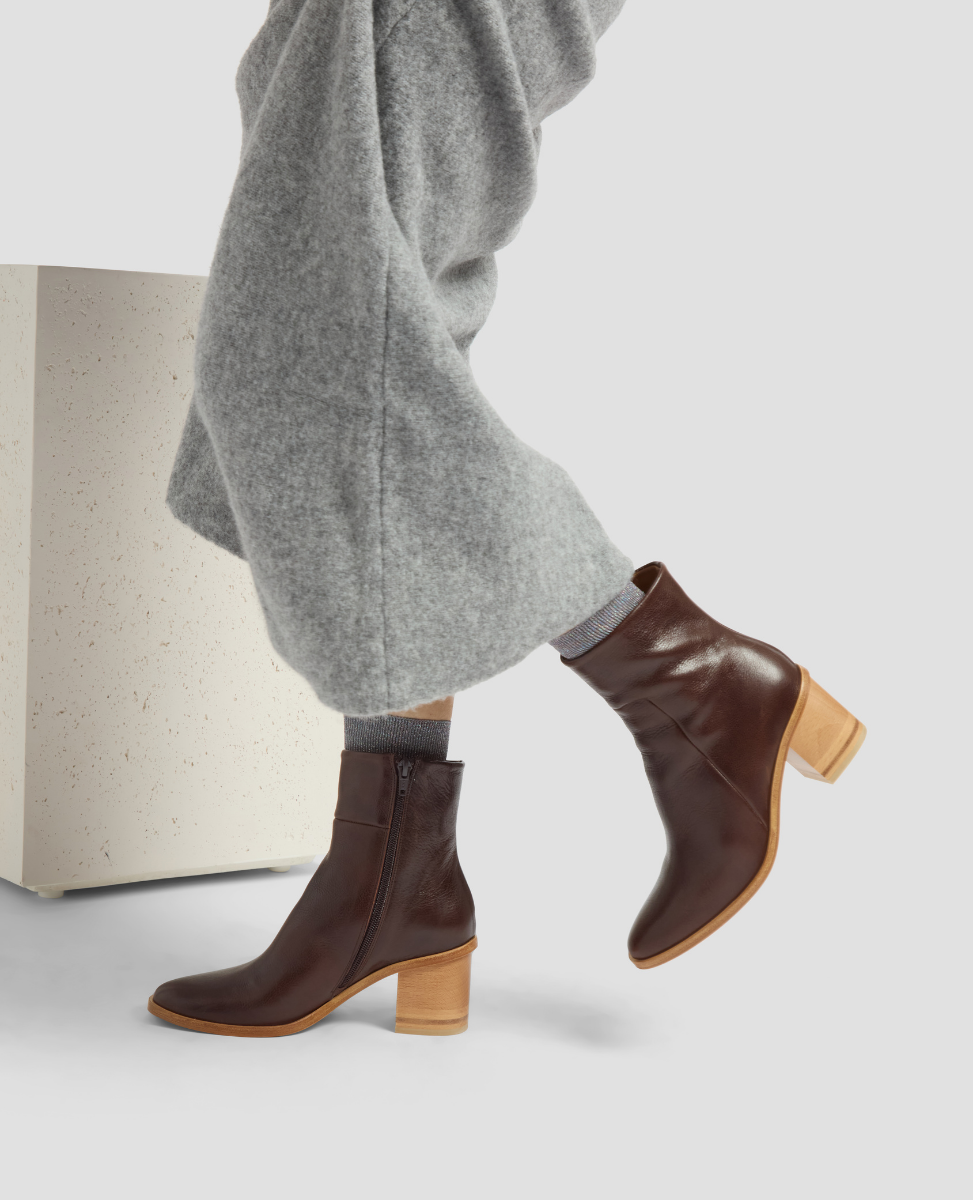Brown ankle boots with wooden heel on a light gray background