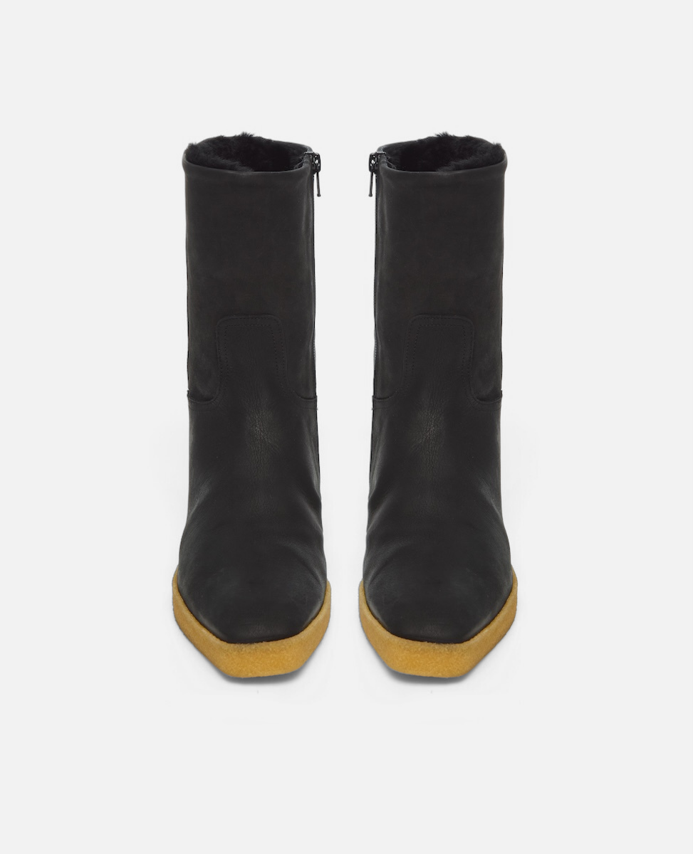 Pair of black boots with yellow soles on a white background
