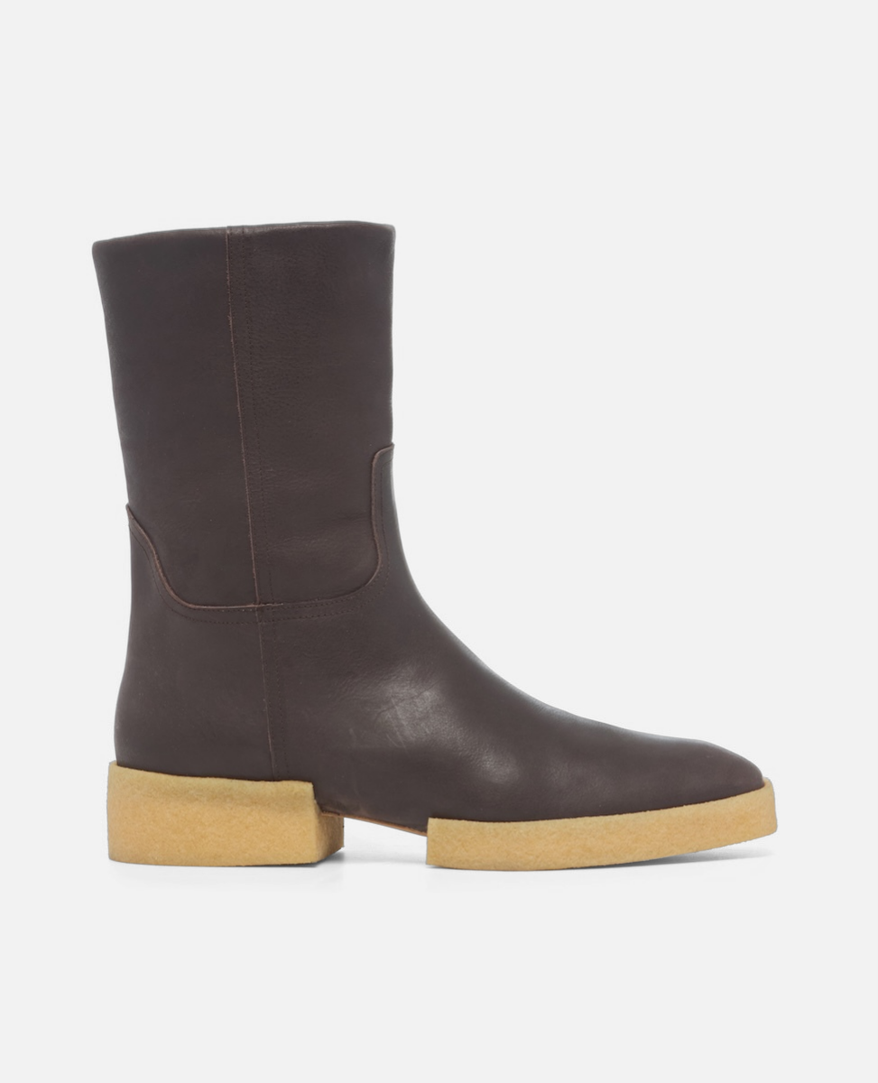 Brown leather boot with a beige sole on a white background