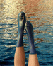 GIF of feet up in the air wearing metallic socks, water moving in the background 2