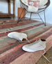 Klava mid-top laceup sneaker in greige nubuck, on a colorful rug 5