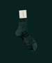A single, dark green sock with a subtle geometric pattern, mid-calf length, made of a smooth, likely synthetic material, featuring a white label attached near the top. Tonal background 1
