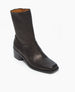 A sleek, black leather ankle boot with a square toe, mid-height stacked heel, and a smooth, polished finish. 7