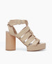 Side view of the April Heel in Latte Macchiato with straps twisting and securing at the ankle by a buckle fastening. 1