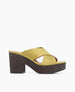 A stylish sandal featuring a mustard yellow crisscross strap design, a chunky dark brown cork platform heel, and an open toe. 3