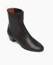 Angled view of the Celeste Boot in black leather: a sleek, mid-heel Chelsea boot with leather-covered gore.  2