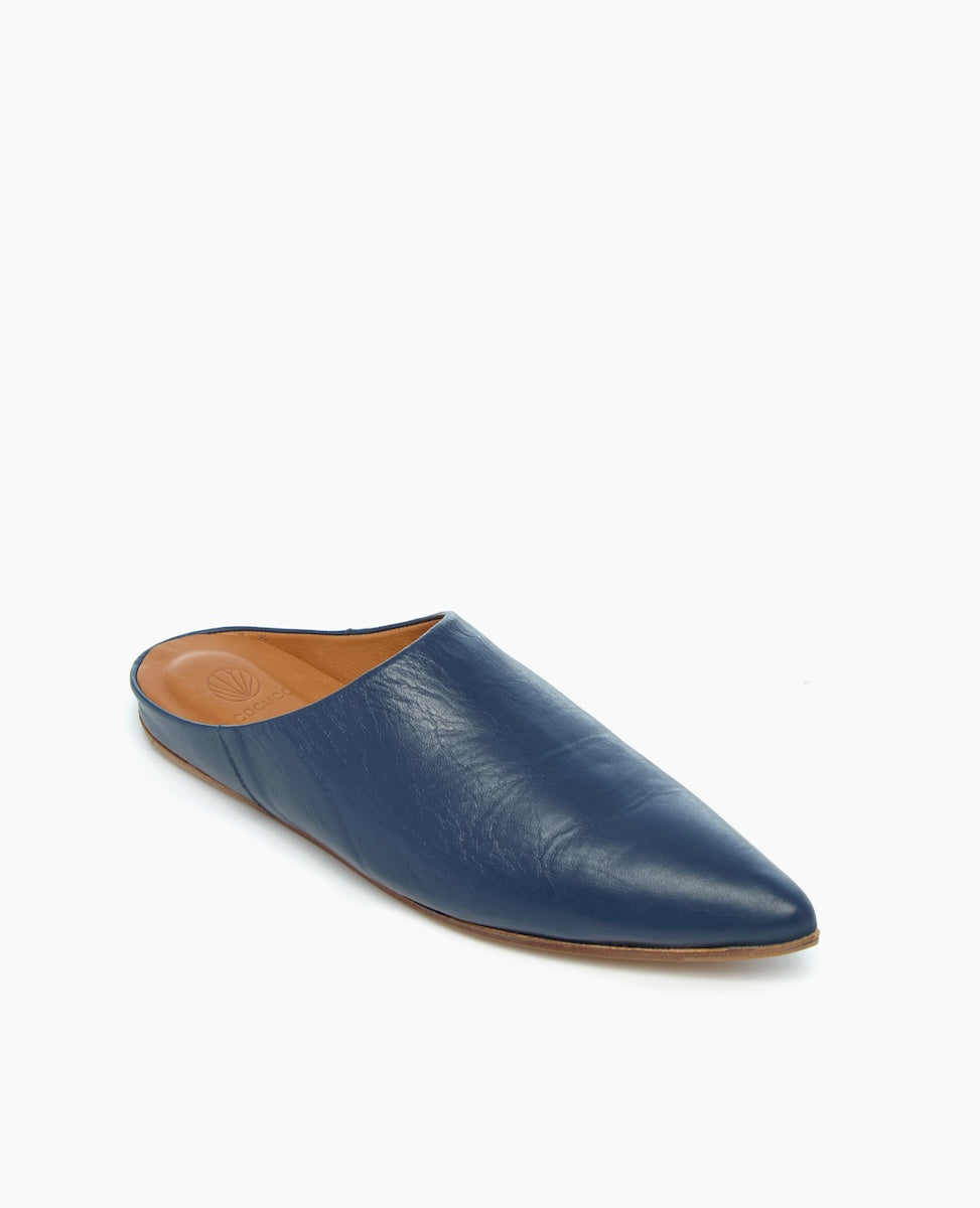 A sleek, pointed-toe mule in deep blue leather with a smooth texture and a tan insole.