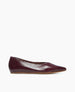 A sleek, burgundy flat shoe with a glossy finish, pointed toe, and smooth leather material, featuring a low-profile design and a thin, light brown sole. 4