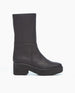 A black, mid-calf leather boot with a smooth, matte finish, featuring a chunky block heel and a slightly rounded toe. 3