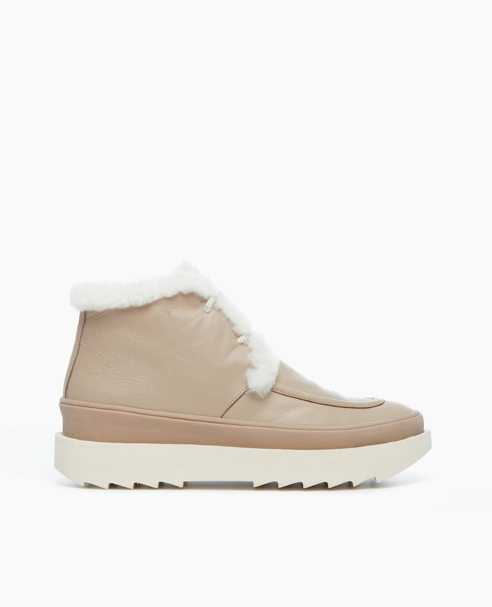 Side view of the Fiona Shearling Bootie in Grey Mist: featuring Italian certified sustainable leather with a lace-up closure and a 50MM wedge with an anatomic foot bed.