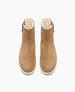 Tan suede ankle boots with a rounded toe, side zipper, plush white lining, and a thick, light-colored rubber sole. 4