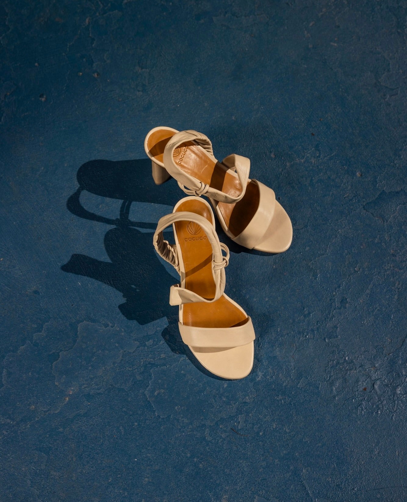 Above view of the Gabby Heel in Latte Macchiato against blue concrete floor. 