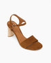 A brown suede sandal with an open toe, featuring a wide front strap, an adjustable ankle strap with a silver buckle, and a cylindrical wooden block heel. 6