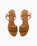 Brown suede sandals with a smooth leather insole, featuring a wide front strap, an adjustable ankle strap with a small buckle, and a flat sole. 7