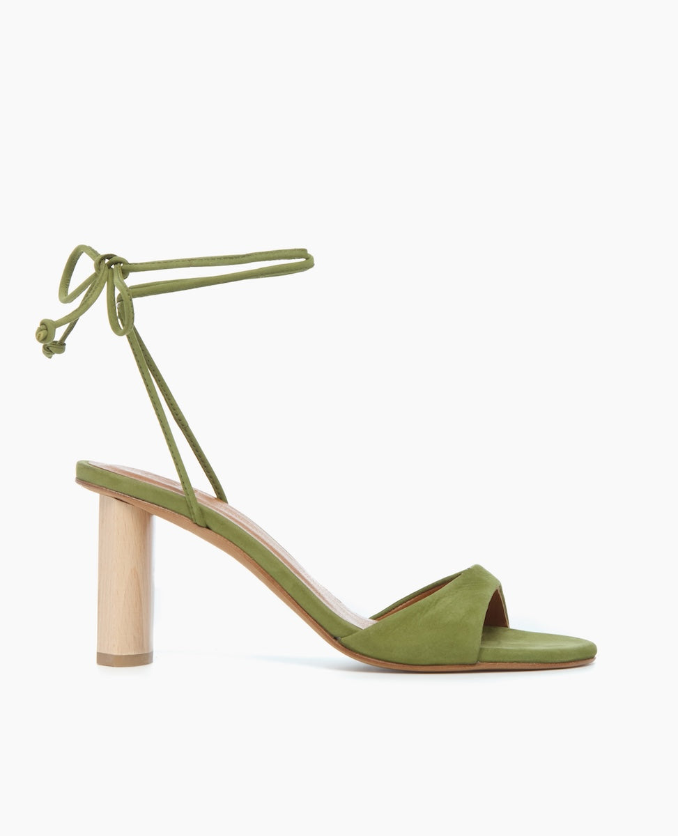 Side view of the Gilda Heel in Mosstone with dainty leather straps that cascade up the ankle finishing in a tie closure.