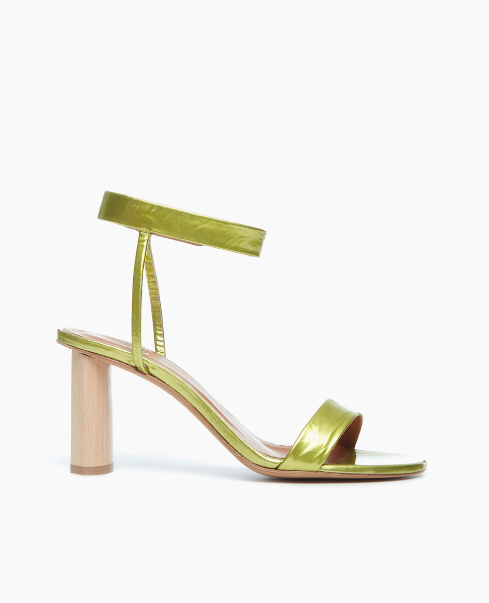 Side view of the Gina Heel in Chartreuse Antiqued Patent, featuring a straight, narrow front strap and ankle strap that is secured with velcro for a supportive and seamless look.