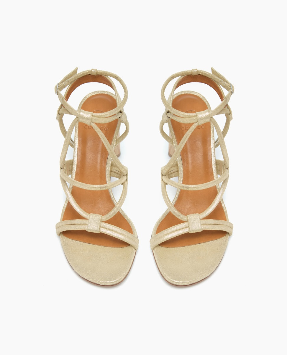 Beige high-heeled sandals with a strappy design, featuring a closed heel and open toe, crafted from smooth leather with a glossy finish.