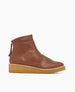 A brown leather ankle boot with a smooth texture, a rounded toe, a flat beige rubber sole, and a zipper at the back. 6