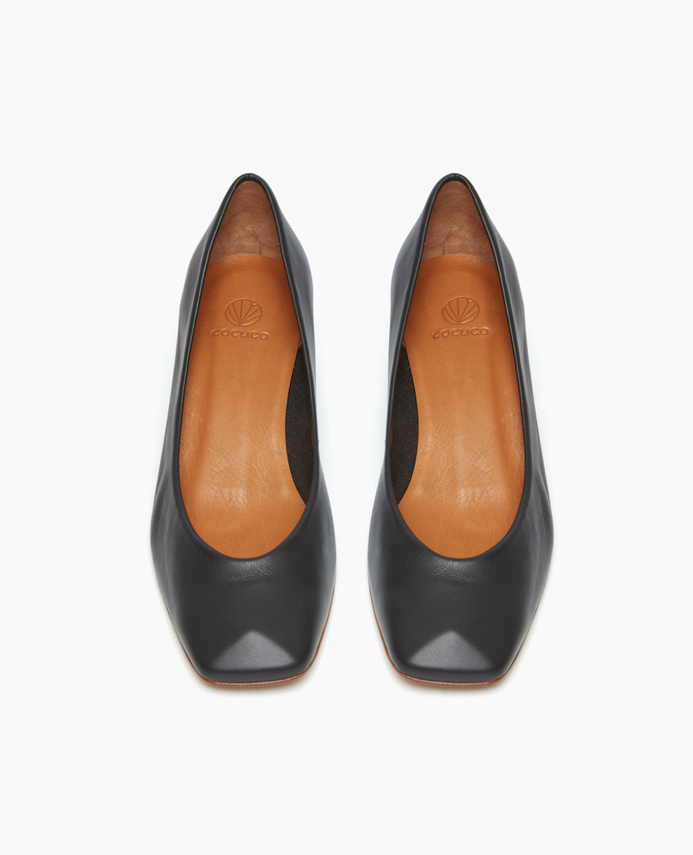 Front view of the Icy Pump in Black Leather with a solid, solid, architectural block wood heel. 