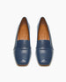 A pair of sleek, blue leather loafers with a square toe design, featuring a smooth texture and a subtle seam across the upper, lined with tan leather interiors. 4