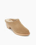 A tan suede mule with a wooden block heel, featuring a rounded toe and a plush, fur-lined interior. 7