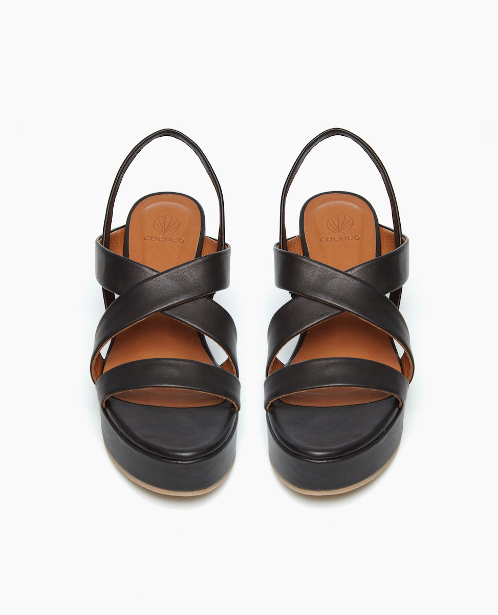 Front view of the Lylo Wedge in Black Leather featuring a lightweight, recycled cork wedge wrapped in leather. 