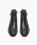 Sleek black ankle boots with a smooth leather finish, almond shaped toes, side zippers, and a low heel, featuring a minimalist design and a slightly glossy texture. 4