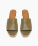 A pair of olive green, open-toe slide sandals with a smooth leather upper, tan leather insole, and a light wooden platform sole. 8