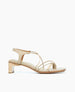 A beige sandal with a low block heel, featuring thin, delicate straps and a smooth leather finish. 2