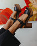 Feet of a woman wearing the Obion Clog in Black with a colorful backdrop. 2