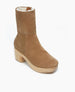 A mid-calf, tan suede boot with a wooden platform heel, featuring a rounded toe, smooth texture, and a cozy, white fleece lining. 4