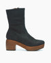 A black leather ankle boot with a smooth texture, featuring a chunky wooden platform heel and a side zipper for closure. 3