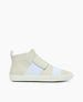 A sleek, high-top sneaker featuring a minimalist design with a light beige and white color scheme, smooth leather texture, a wide velcro strap across the top, and a flat rubber sole. 2