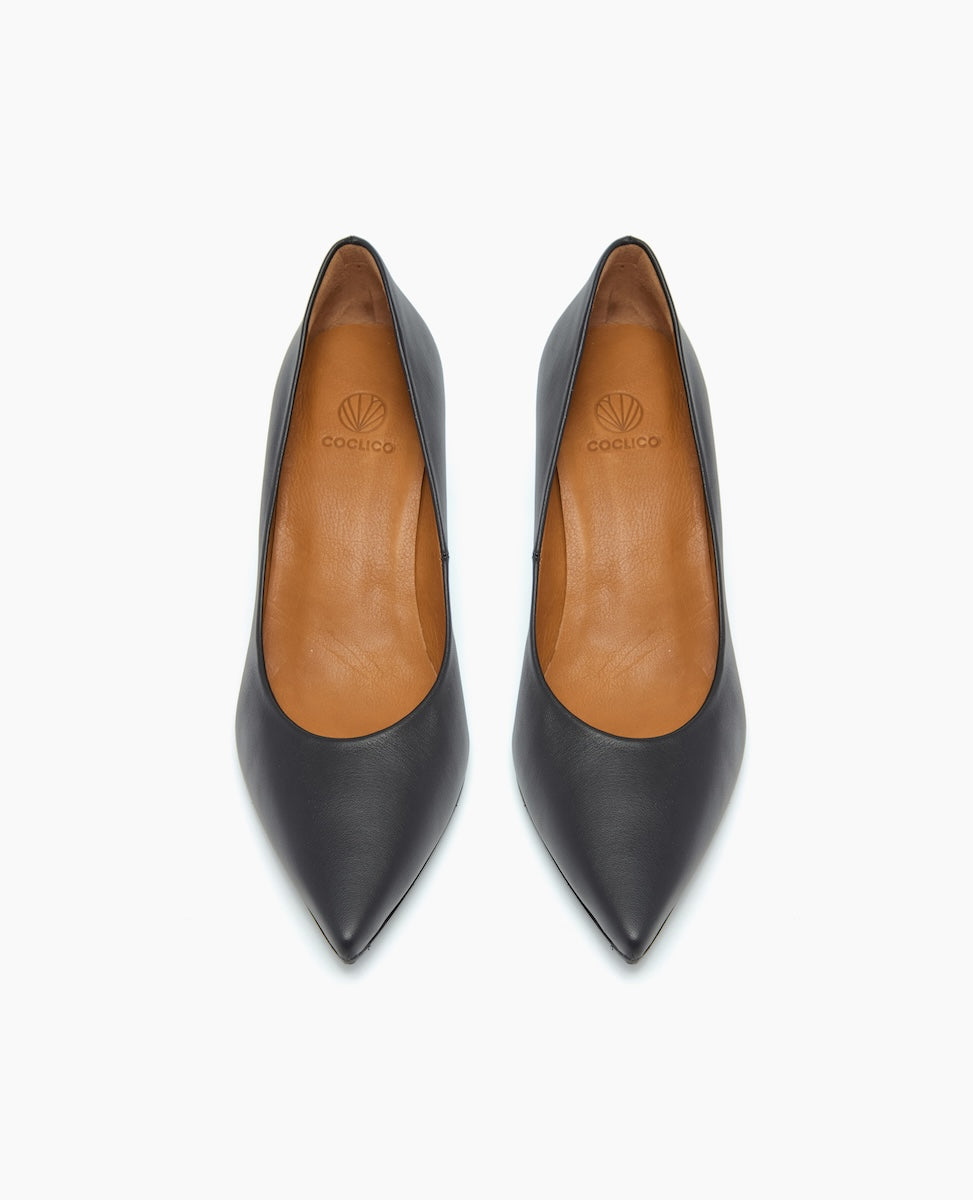 A pair of sleek, black leather high-heeled shoes with a pointed toe, tan leather interior, and a subtle logo embossed on the insole.