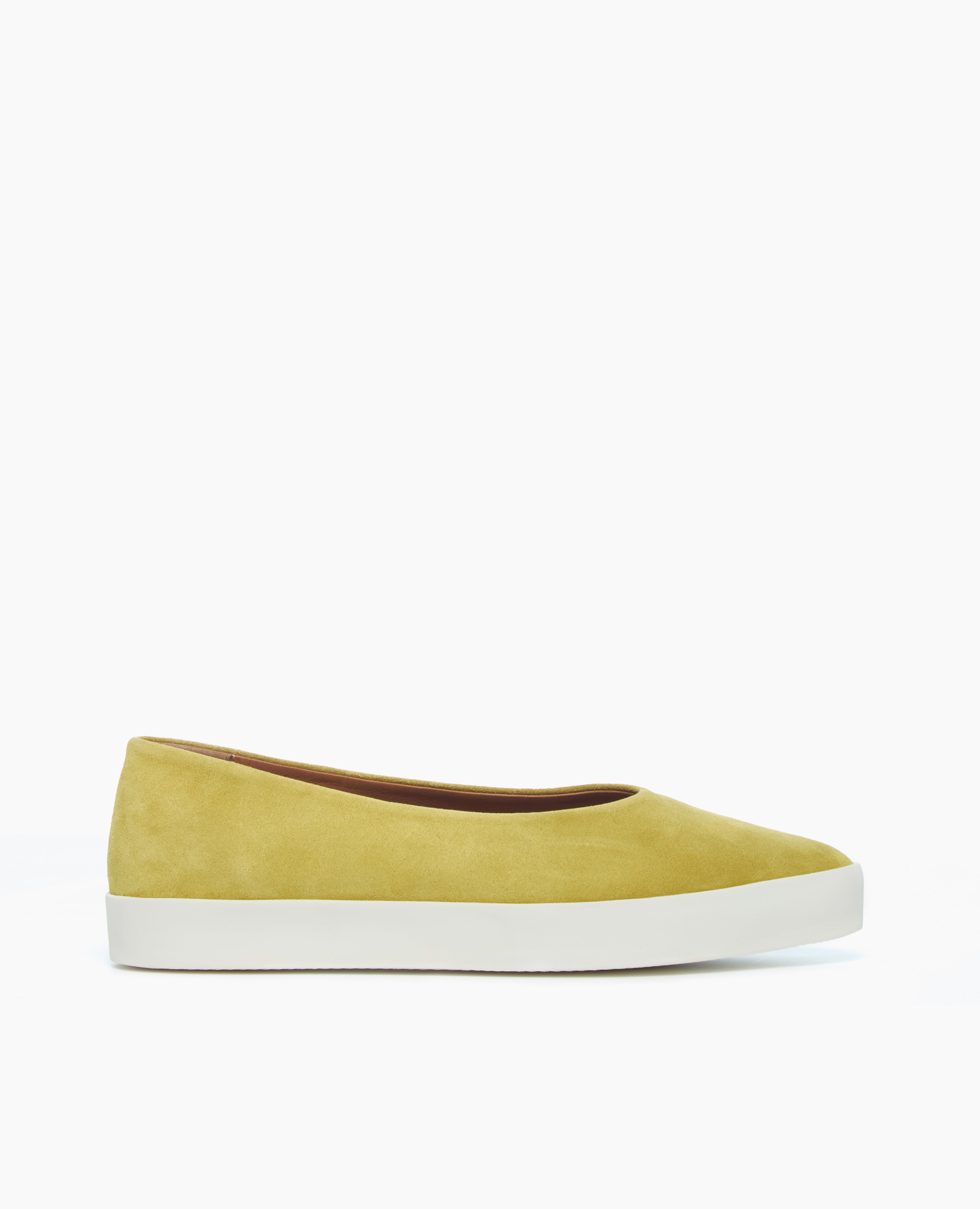 A mustard yellow suede slip-on shoe with a smooth texture, a rounded toe, and a thick white rubber sole.