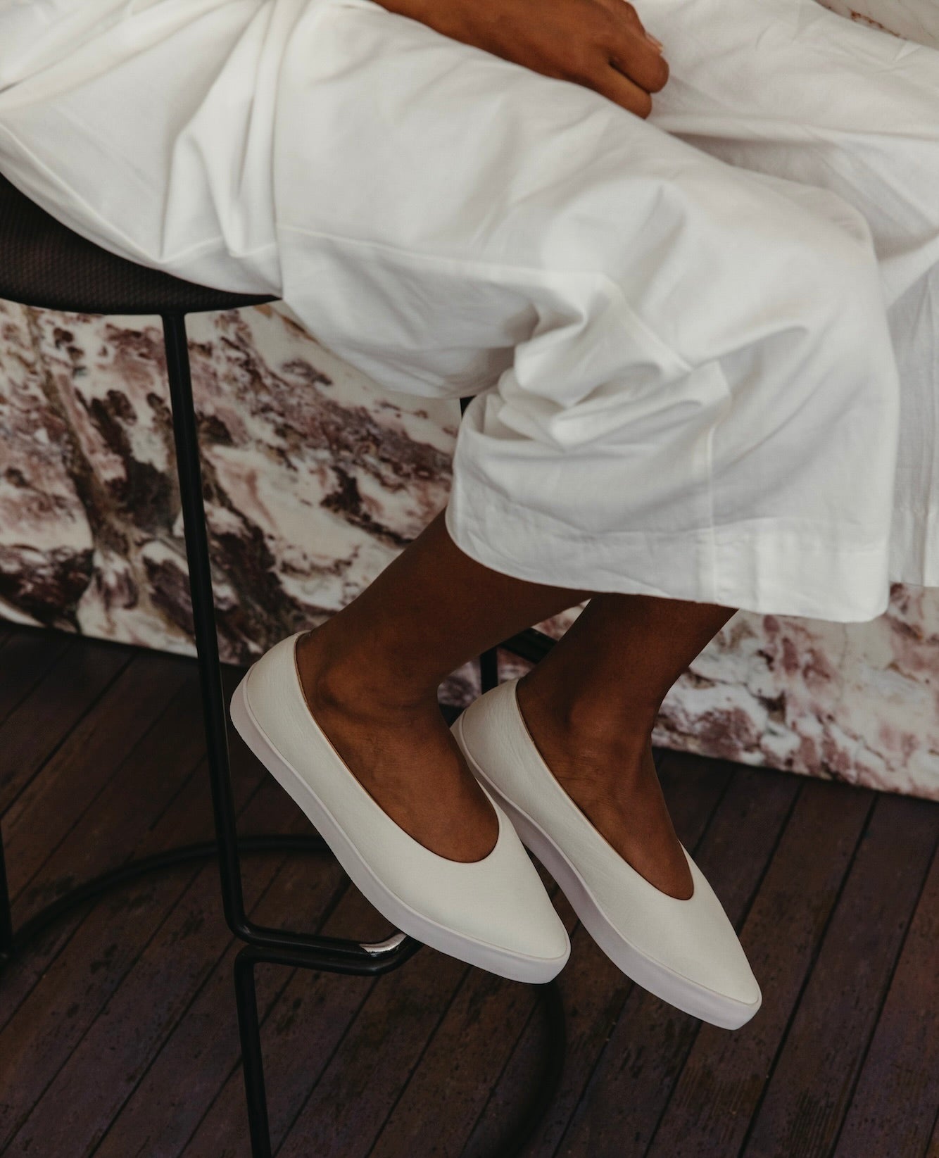 Regal Sneaker in greige on model sitting on a bar stool