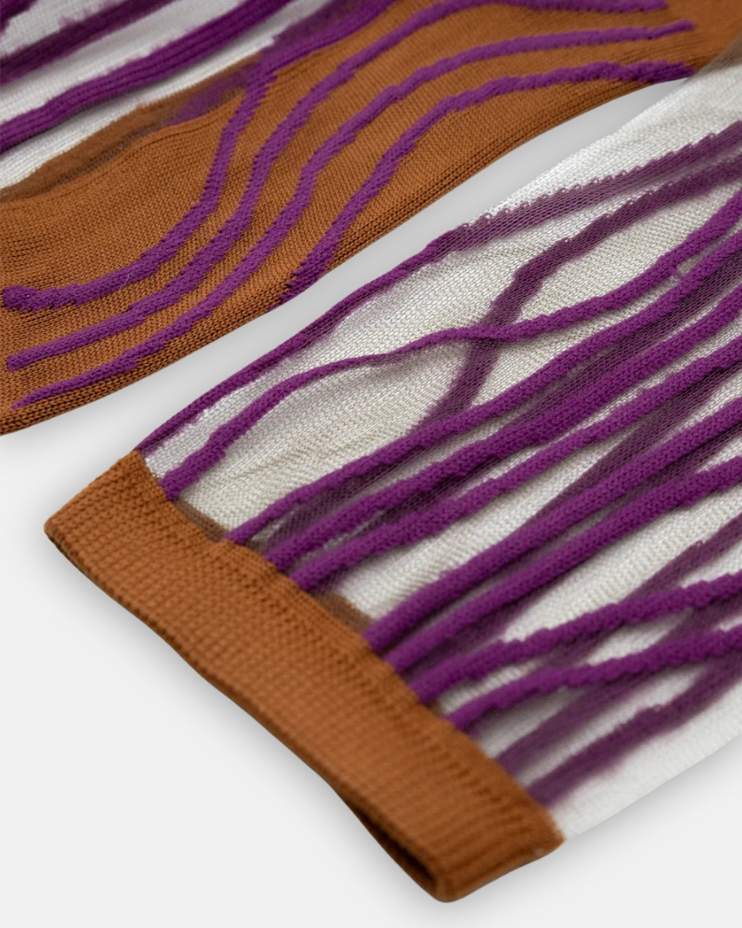 Pair of sheer Superkilen Prune socks with wavy purple lines and orange cuffs, laid flat on a light gray background