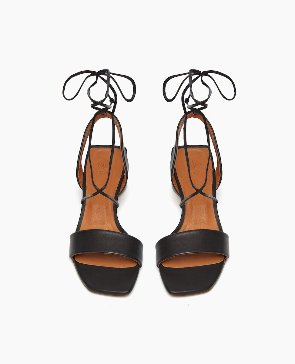 Front view of the Steph in Black leather featuring a wide front strap and cascading tie closures.