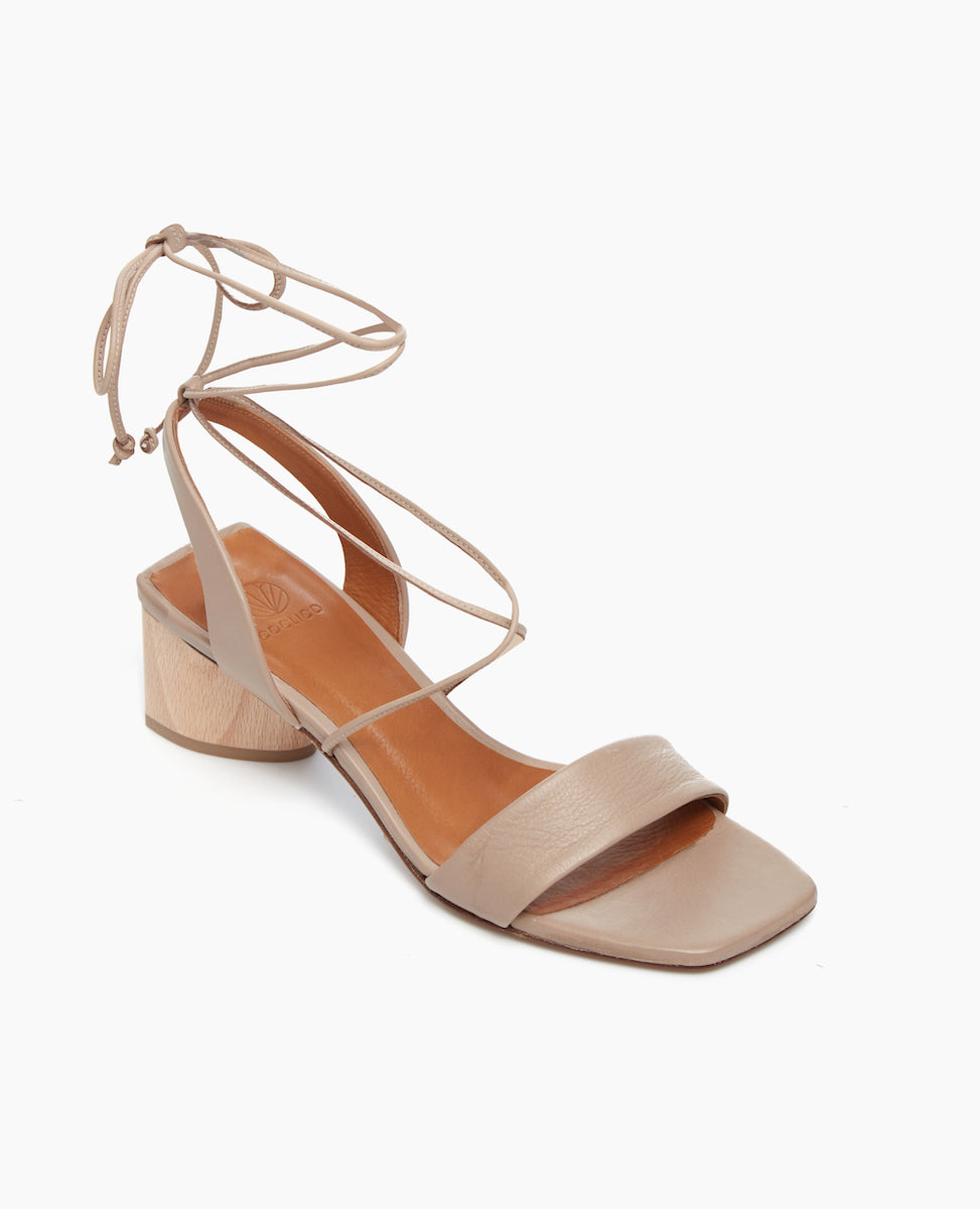 Angled view of the Steph Heel in Grey Mist featuring a comfortable leather front band and a winding of leather straps that cascade up the ankle with a tie closure.