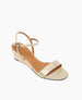 A sleek, open-toe sandal with a metallic gold finish, featuring a low wedge heel, a single front strap, and a thin ankle strap with a small buckle. 4