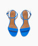 Bright blue sandals with a minimalist design feature a single wide strap across the toes, an adjustable ankle strap with a buckle, and a tan insole with a logo imprint. 4