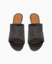 A pair of sleek, black slide sandals with a smooth, wide strap and a tan insole featuring a subtle embossed logo. 4