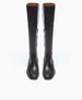 Tall, sleek black leather boots with a smooth texture, a slightly squared toe, and a knee-high length, featuring a subtle seam running vertically along the front and back. 6