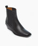 A sleek, black leather ankle boot with a squared toe, low wedge heel, elastic side panels, and a pull tab at the back. 2